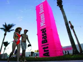 A couple walking in front of a pink tower.